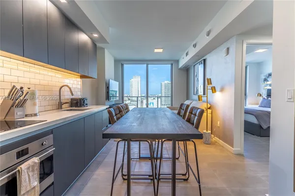 a kitchen with a table chairs sink and cabinets