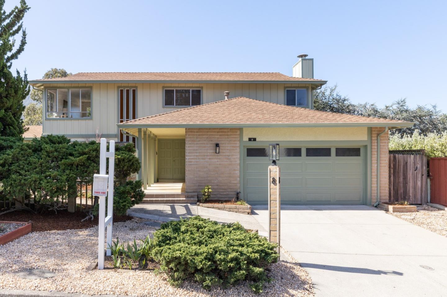 a front view of a house with a garden