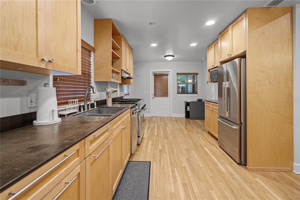 1017 Northeast 3rd Avenue Gainesville, FL 32601 - Photo 14 of 27 a kitchen with stainless steel appliances granite countertop a sink stove and refrigerator