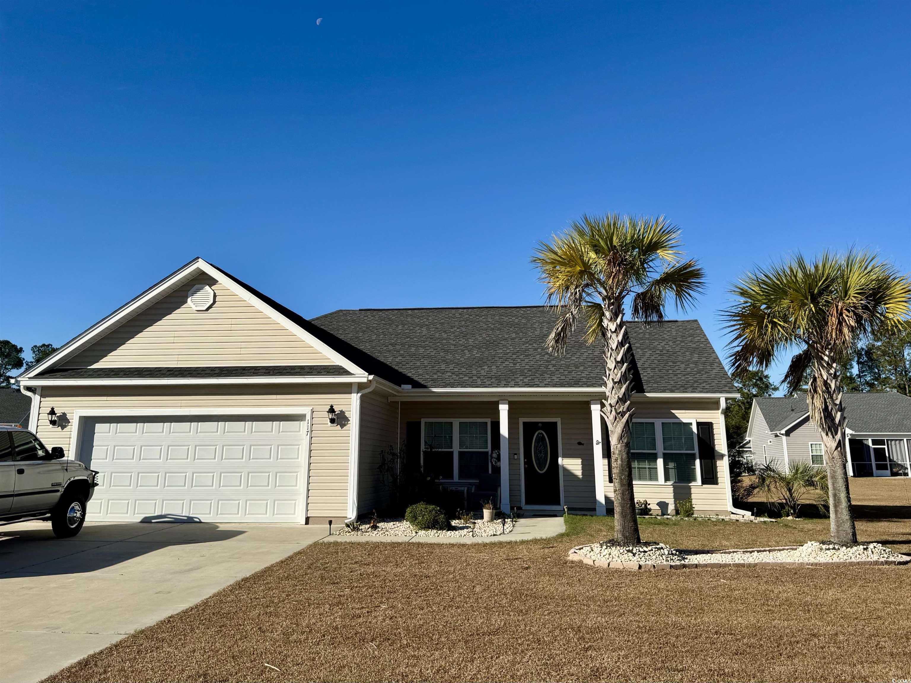 Single story home with covered porch, driveway, a garage, and roof with shingles