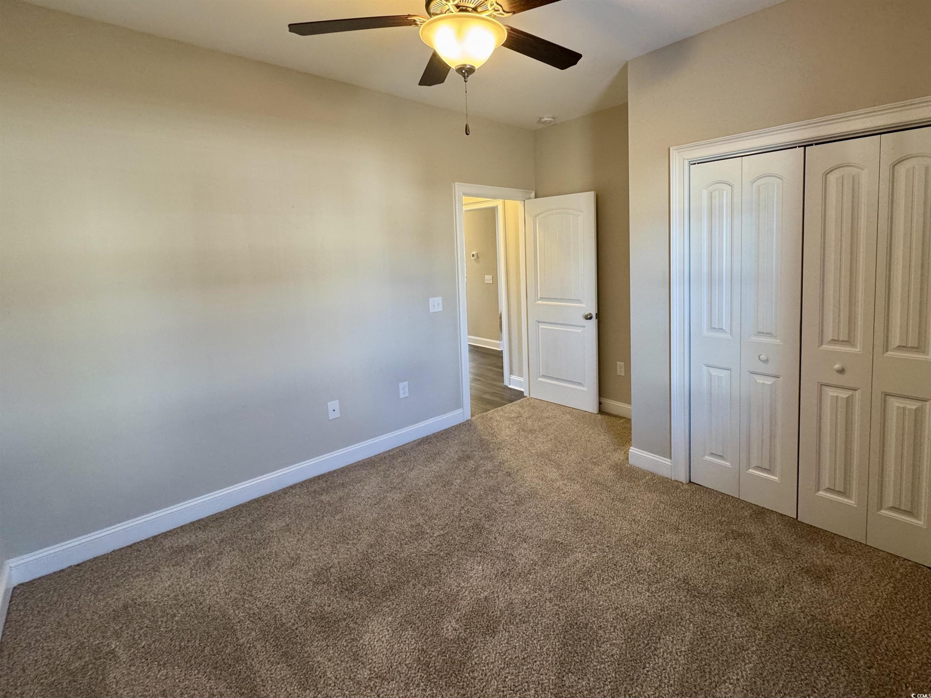 117 Baylee Circle Galivants Ferry, SC 29544 - Photo 14 of 17 Unfurnished bedroom with a closet, dark carpet, and ceiling fan