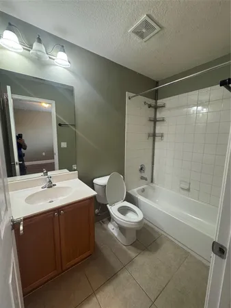 a bathroom with a sink a toilet a mirror and shower