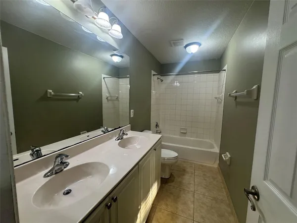 a bathroom with a sink double vanity granite tub and shower