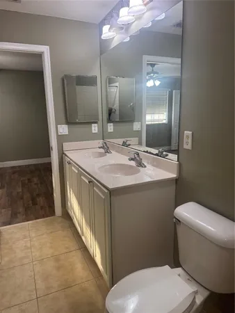 a bathroom with a sink a toilet a mirror and vanity