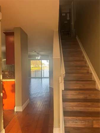 a view of a hallway with wooden floor and staircase
