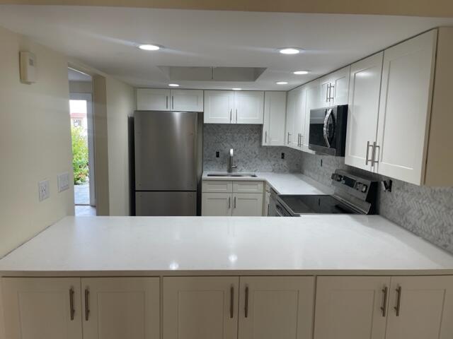 3243 Beach View Way Melbourne Beach, FL 32951 - Photo 8 of 35 a kitchen with stainless steel appliances a refrigerator sink and microwave
