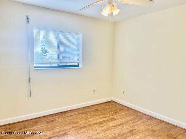 3243 Beach View Way Melbourne Beach, FL 32951 - Photo 10 of 35 an empty room with a chandelier fan and wooden floor