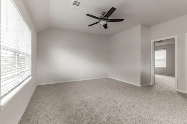 an empty room with a window and a fan