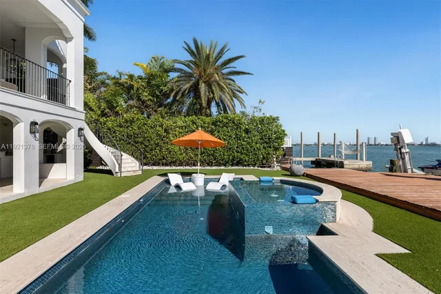 a view of a house with pool and chairs