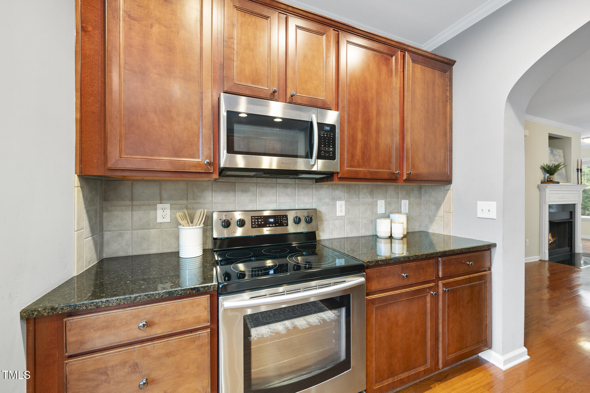 5006 Celtic Court Raleigh, NC 27612 - Photo 8 of 28 a kitchen with granite countertop wooden cabinets and a stove top oven