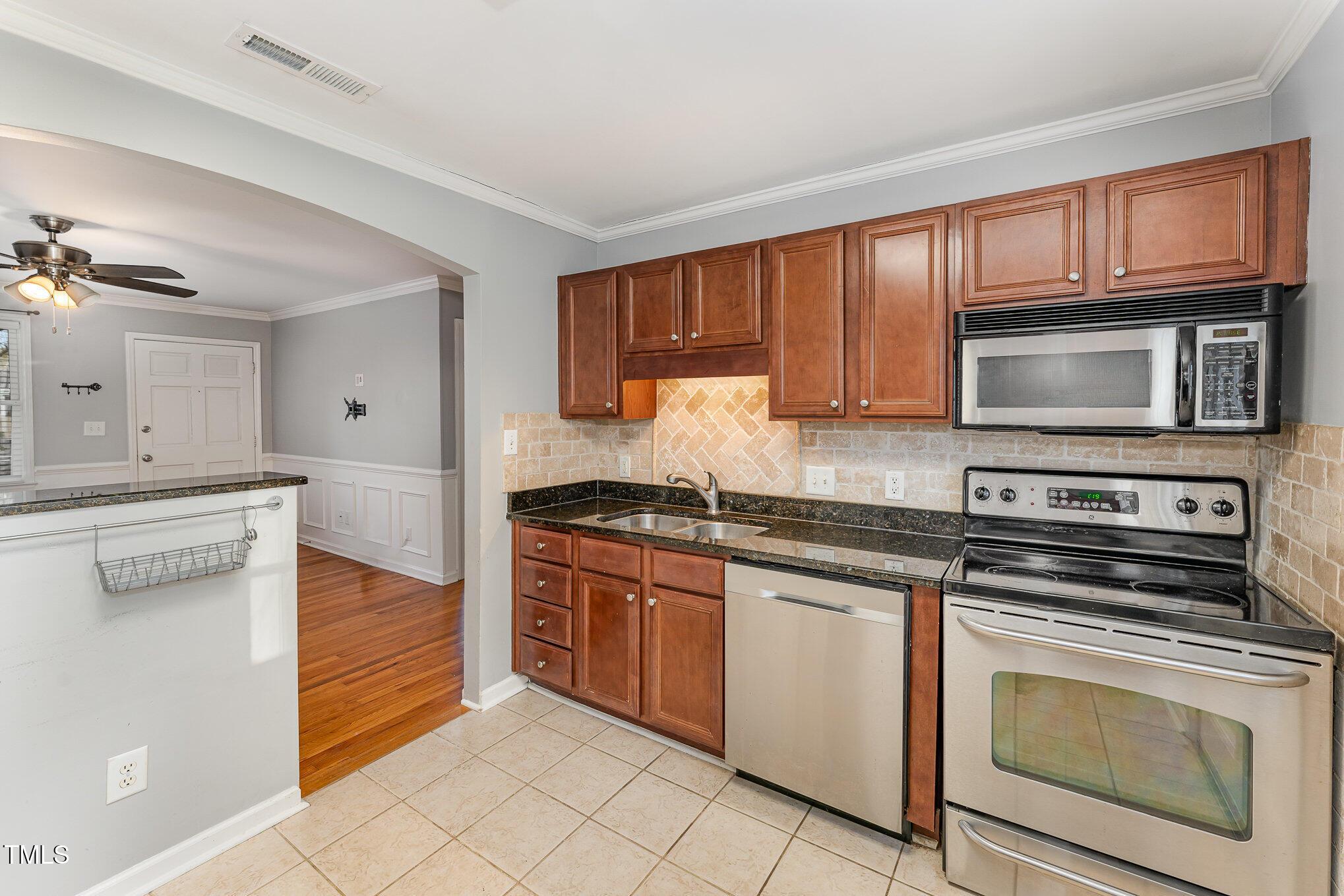 2302 Bernard Street Raleigh, NC 27608 - Photo 6 of 16 a kitchen with stainless steel appliances granite countertop a stove microwave and cabinets