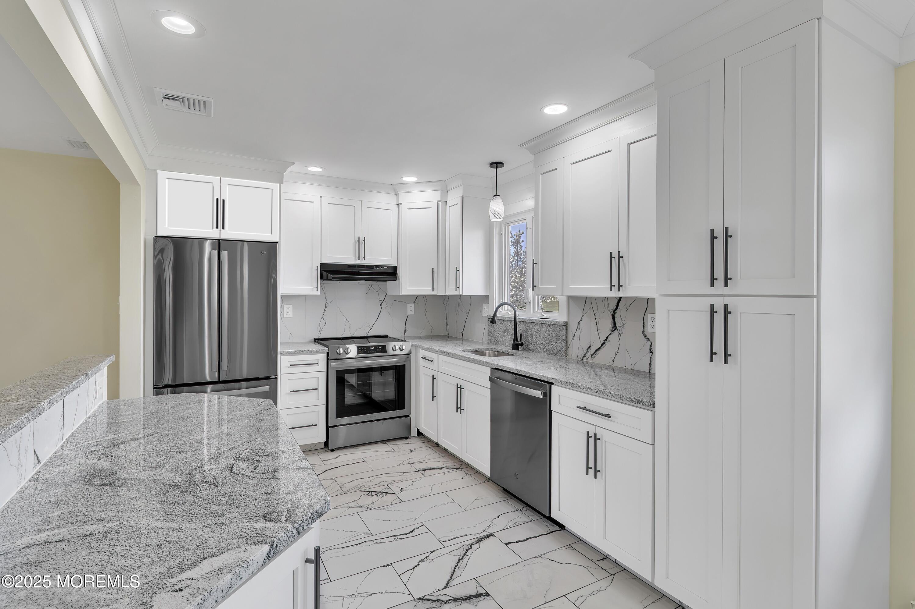 1 Markham Road Brick, NJ 08724 - Photo 4 of 63 a kitchen with white cabinets and stainless steel appliances