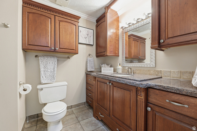 2342 Charros Road Sandy, UT 84092 - Photo 26 of 94 Bathroom with wood cabinetry featuring upper storage and a vanity with a dark speckled countertop