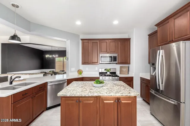 a kitchen with stainless steel appliances granite countertop a sink stove and refrigerator