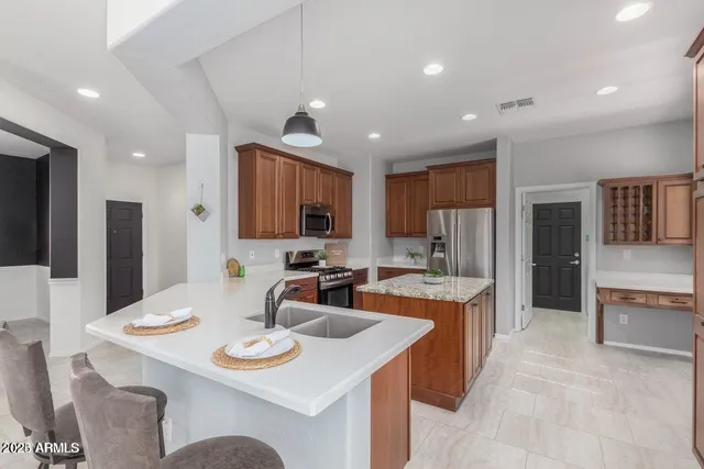 a kitchen with a sink a stove a refrigerator and chairs