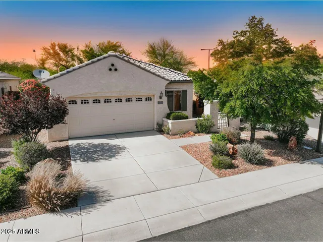 a view of a house with a yard and potted plants