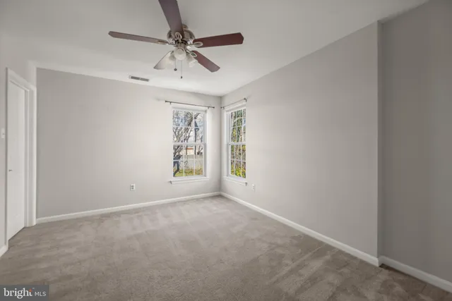a view of a hallway with a ceiling fan