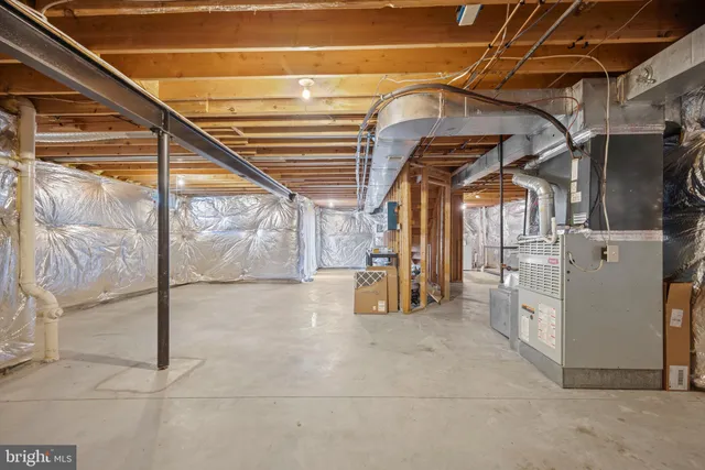 an empty room with chandelier fan and windows