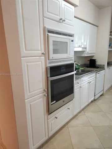 a bathroom with a granite countertop sink mirror vanity and toilet