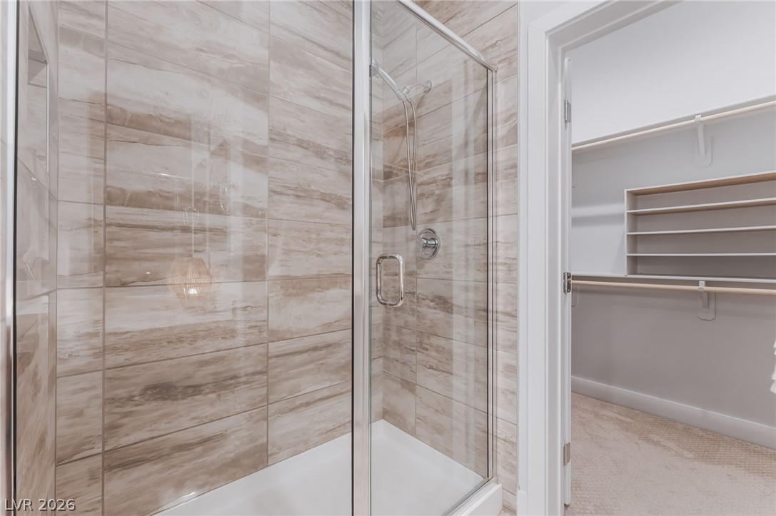 6432 Spring Jog Street Las Vegas, NV 89166 - Photo 23 of 61 A well-appointed shower with stylish tilework and a convenient walk-in closet adjacent.