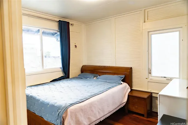 a bedroom with a bed and two windows