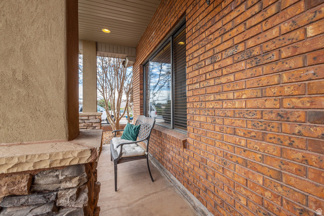 892 Cambridge Drive St. George, UT 84770 - Photo 6 of 65 Inviting covered porch featuring a brick exterior wall, stucco column, and stone-clad pillar base