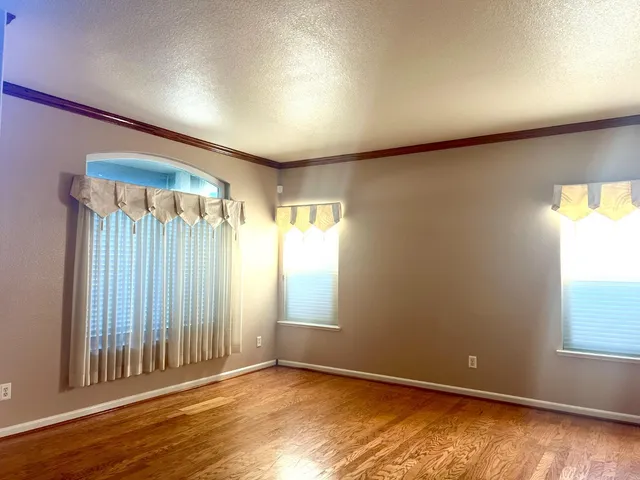 an empty room with wooden floor and a window
