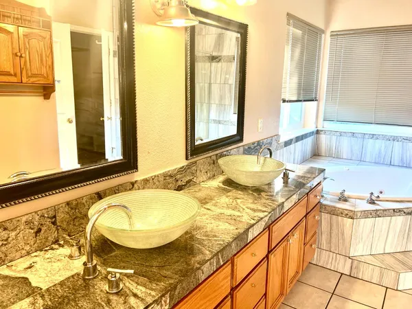 a bathroom with a granite countertop tub and a sink