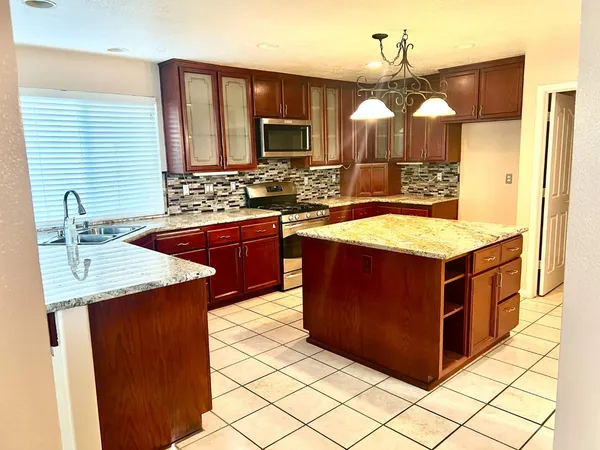 a kitchen with stainless steel appliances granite countertop a sink and a stove