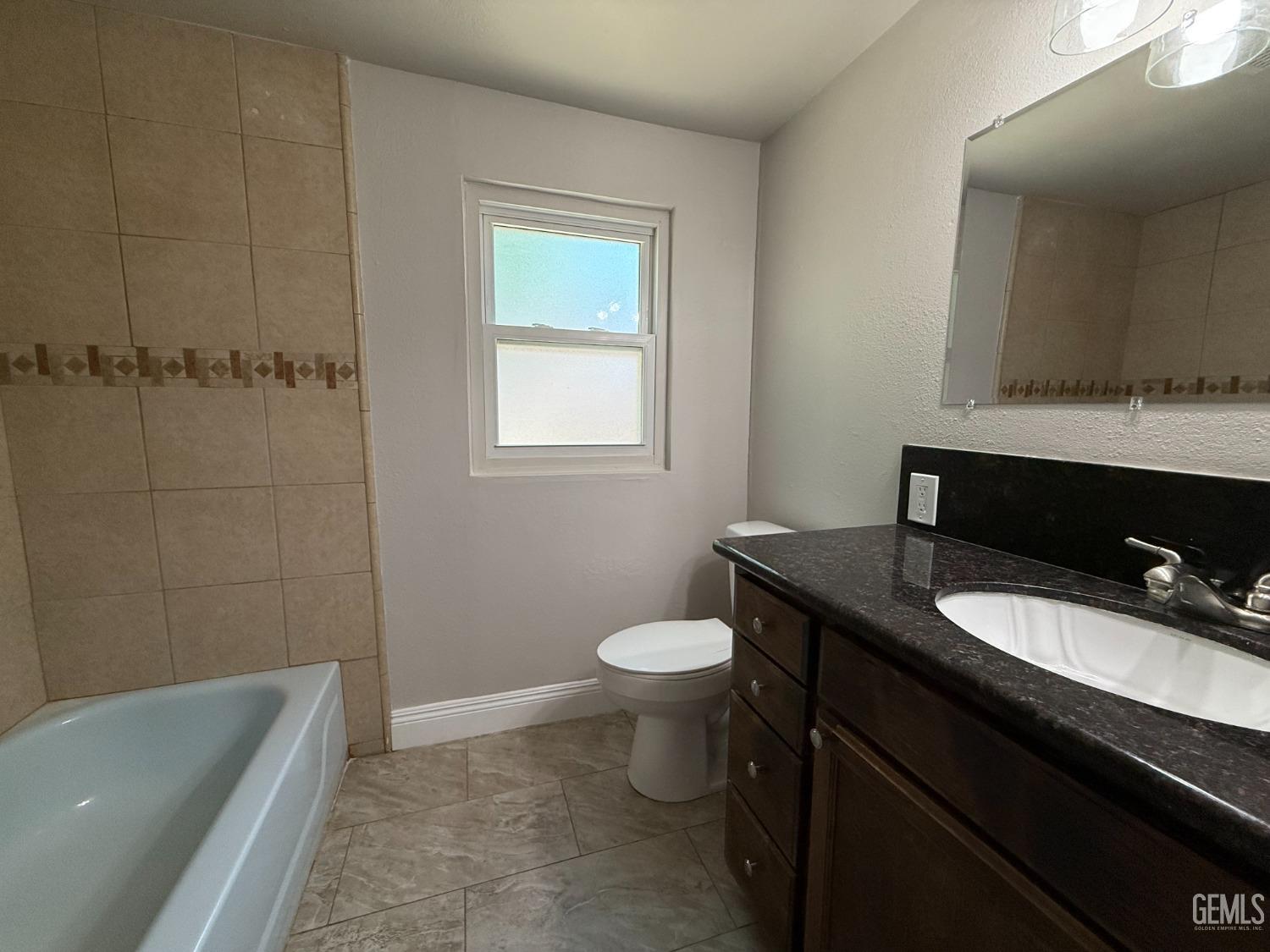 Undisclosed Address Bakersfield, CA 93307 - Photo 11 of 27 a bathroom with a granite countertop toilet sink and mirror