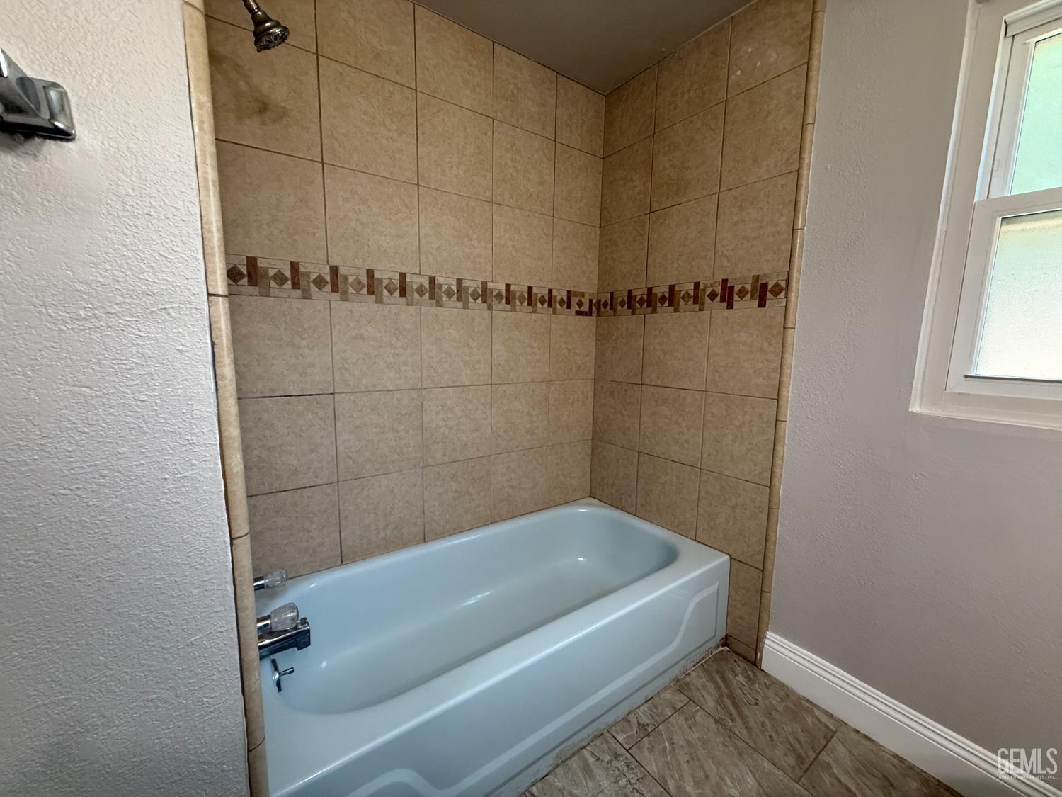 Undisclosed Address Bakersfield, CA 93307 - Photo 12 of 27 a bathroom with a bathtub