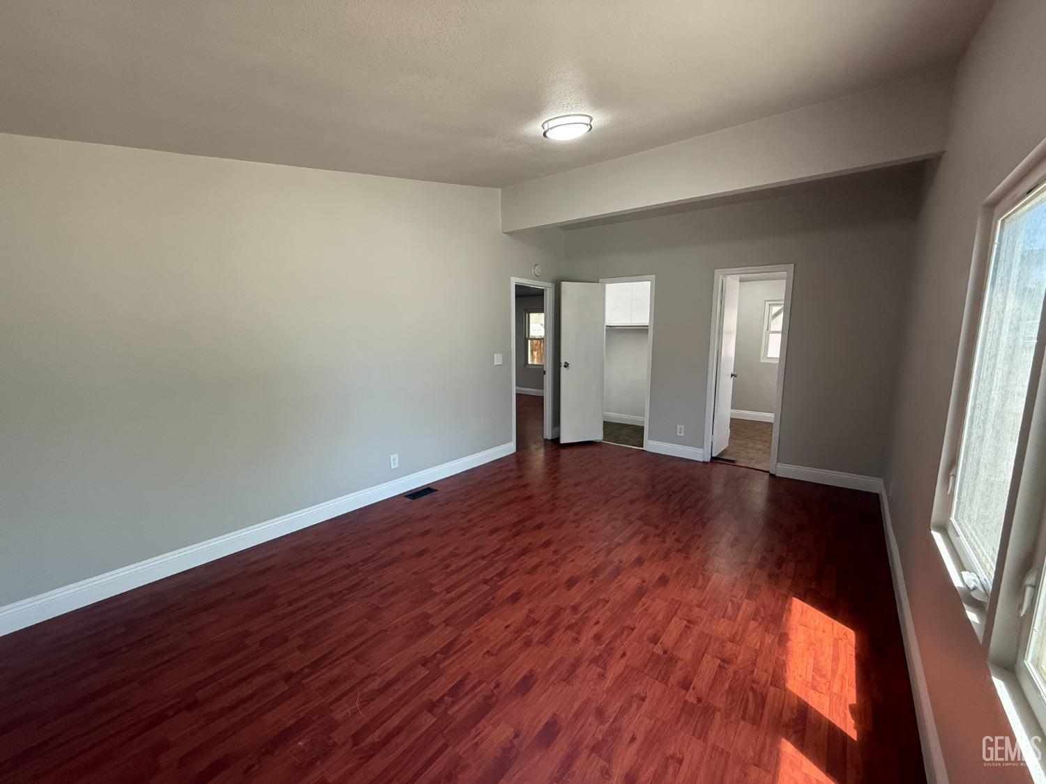 Undisclosed Address Bakersfield, CA 93307 - Photo 15 of 27 an empty room with wooden floor and windows