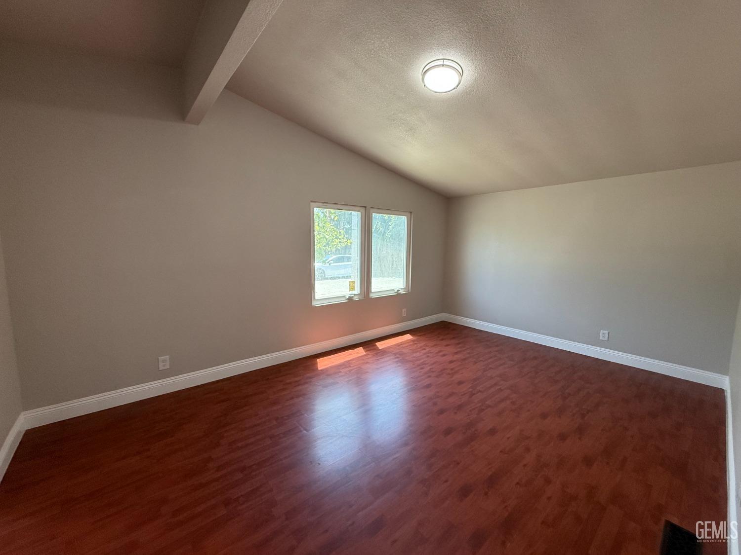 Undisclosed Address Bakersfield, CA 93307 - Photo 16 of 27 an empty room with wooden floor and windows