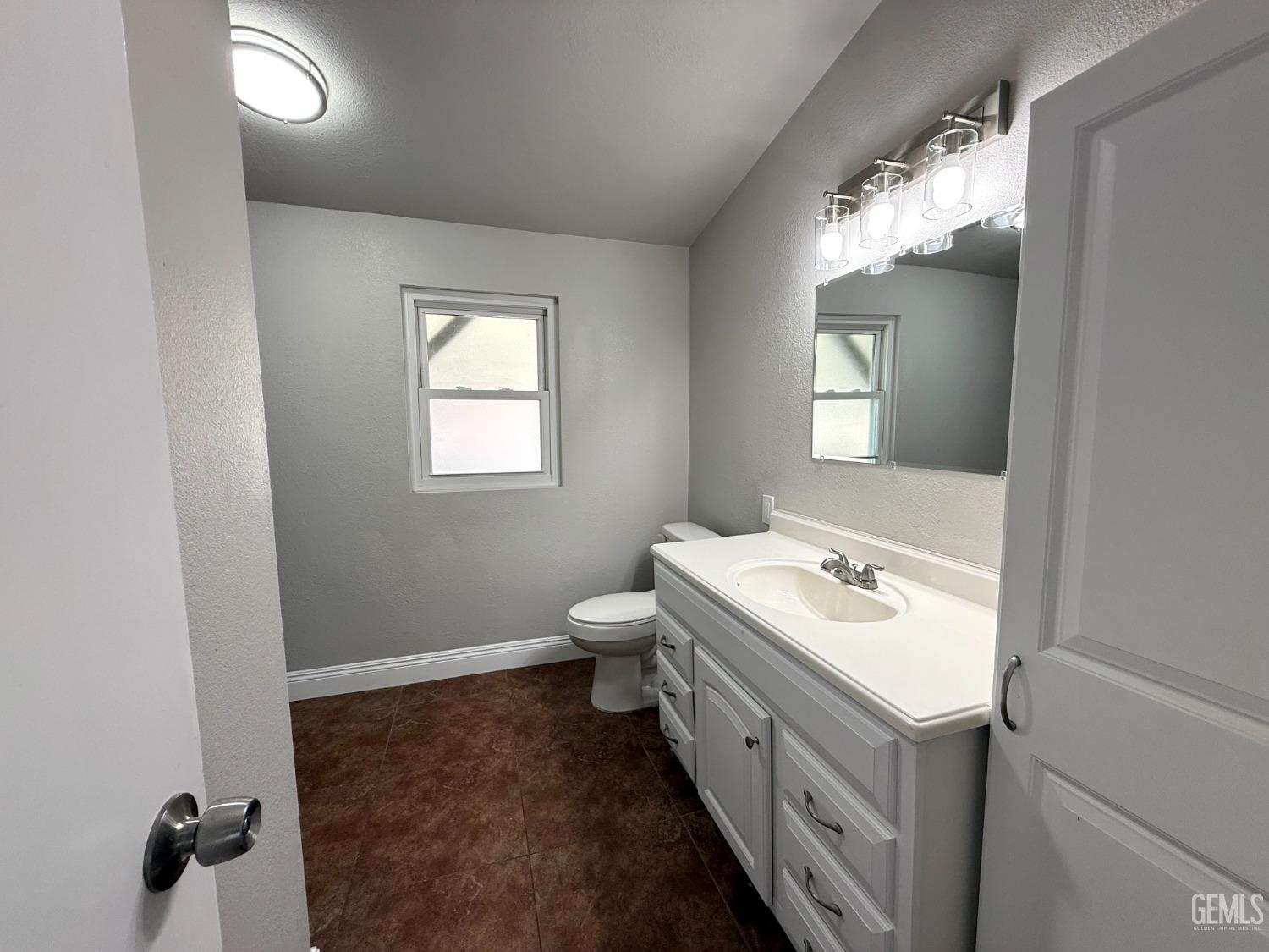 Undisclosed Address Bakersfield, CA 93307 - Photo 17 of 27 a bathroom with a sink a toilet and mirror