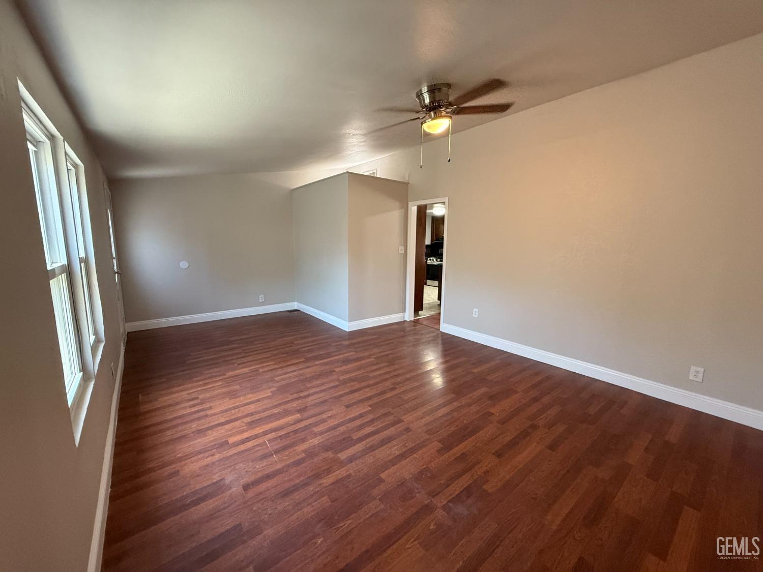 Undisclosed Address Bakersfield, CA 93307 - Photo 21 of 27 an empty room with wooden floor fan and windows