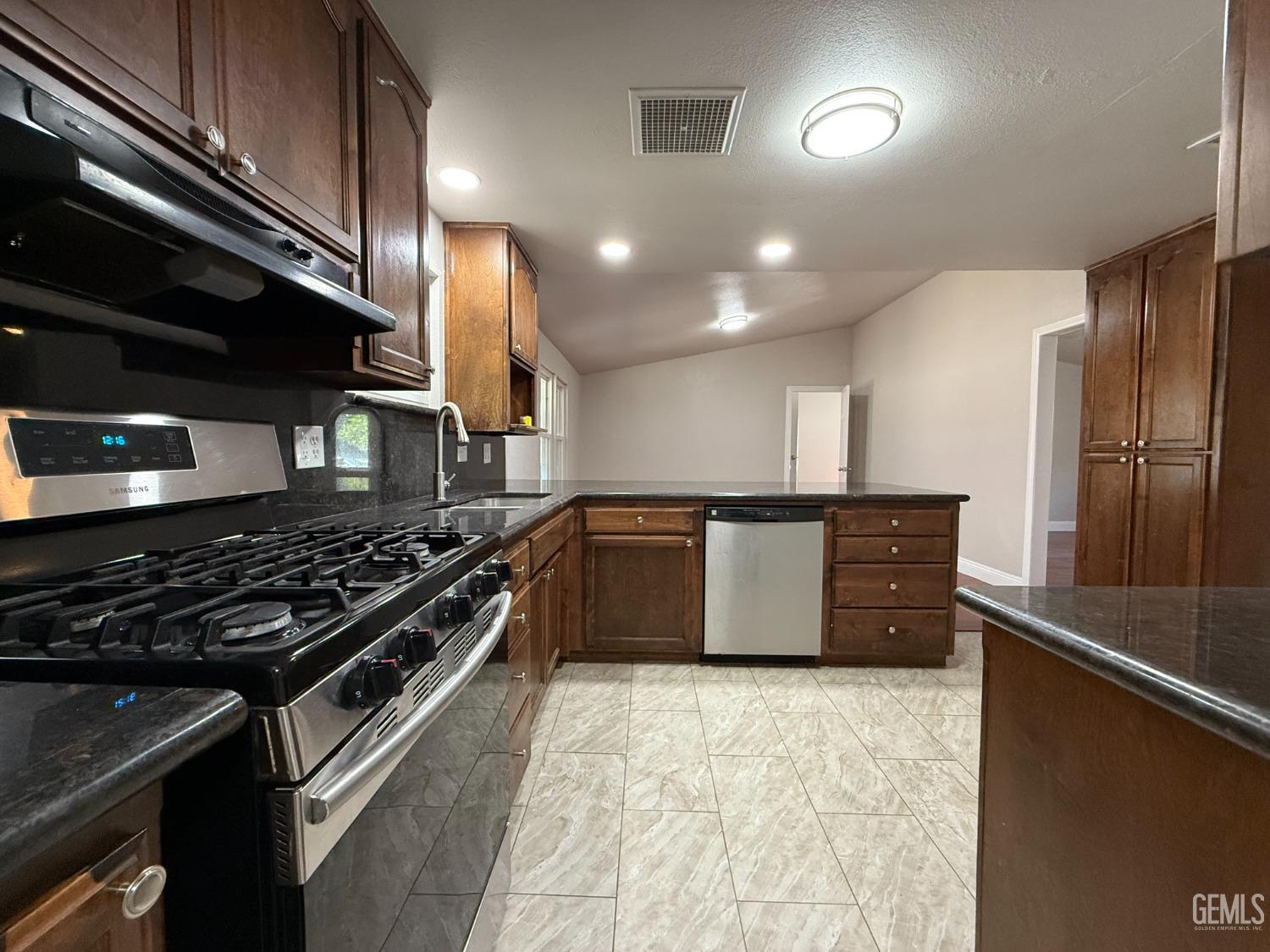 Undisclosed Address Bakersfield, CA 93307 - Photo 3 of 27 a kitchen with stainless steel appliances granite countertop a stove a sink and a refrigerator