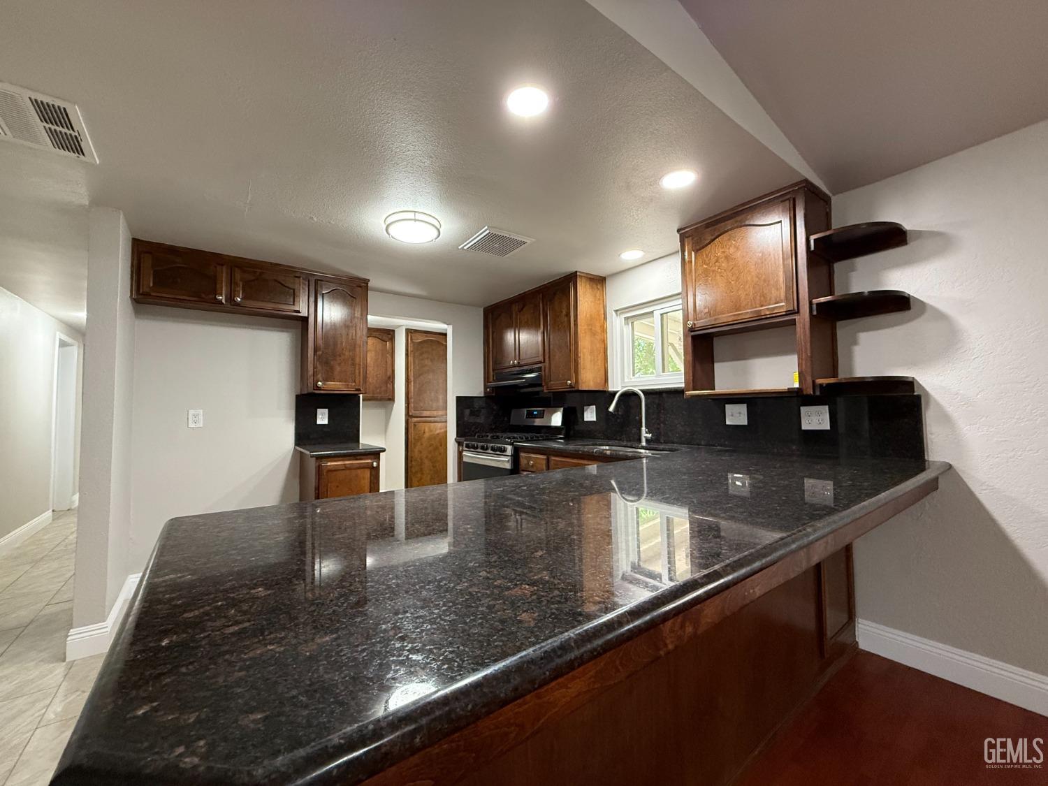 Undisclosed Address Bakersfield, CA 93307 - Photo 4 of 27 a kitchen with stainless steel appliances granite countertop a sink refrigerator and stove