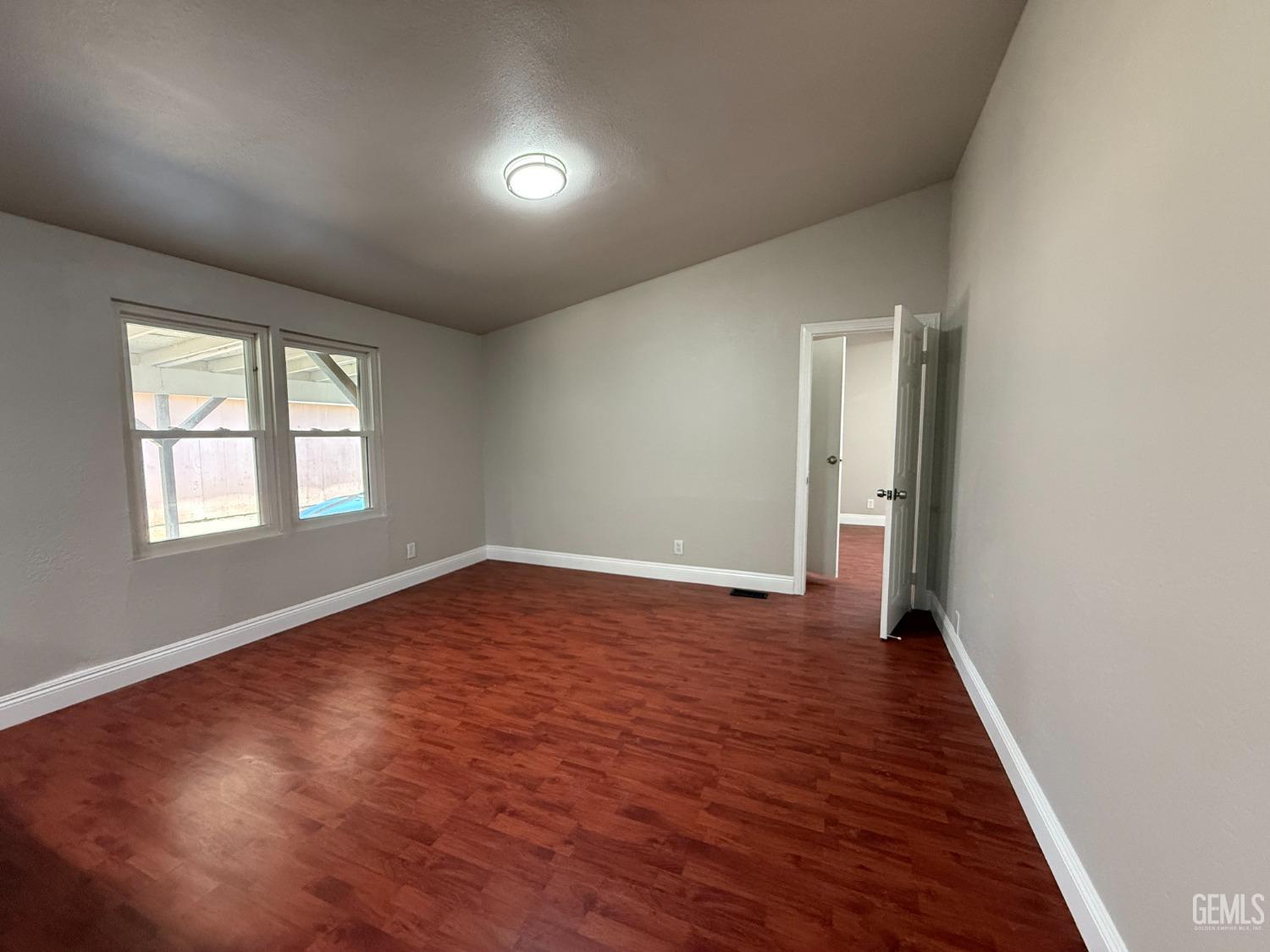 Undisclosed Address Bakersfield, CA 93307 - Photo 8 of 27 an empty room with wooden floor and windows