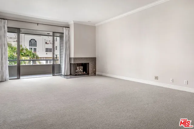 an empty room with fireplace and a window
