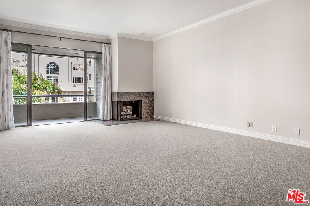 11808 Dorothy Street, Unit 206 Los Angeles, CA 90049 - Photo 18 of 33 an empty room with fireplace and a window