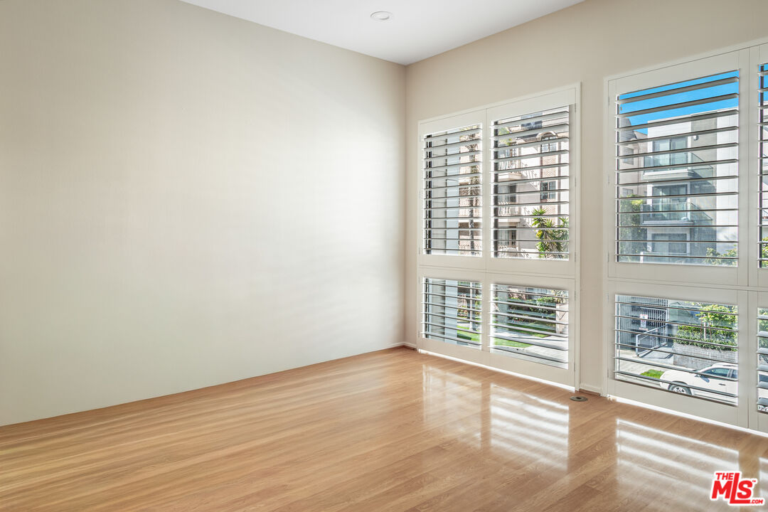11808 Dorothy Street, Unit 206 Los Angeles, CA 90049 - Photo 24 of 33 a view of an empty room with wooden floor and a window