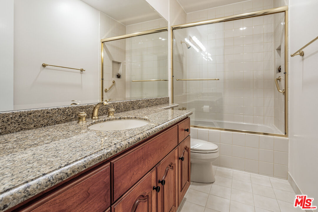 11808 Dorothy Street, Unit 206 Los Angeles, CA 90049 - Photo 27 of 33 a bathroom with a granite countertop sink toilet and shower