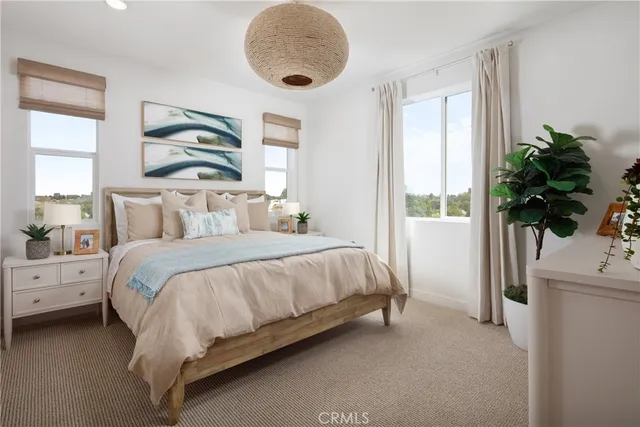 a bedroom with a large bed and a flat tv screen on dresser