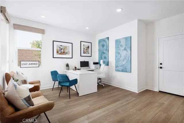 a living room with furniture a desk and chair with wooden floor