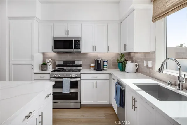 a kitchen with stainless steel appliances granite countertop a sink and stove top oven