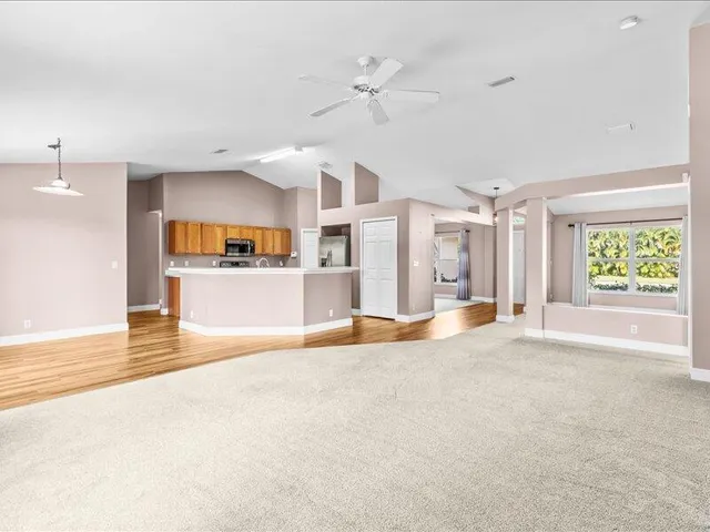 a living room with stainless steel appliances kitchen island granite countertop wooden floor