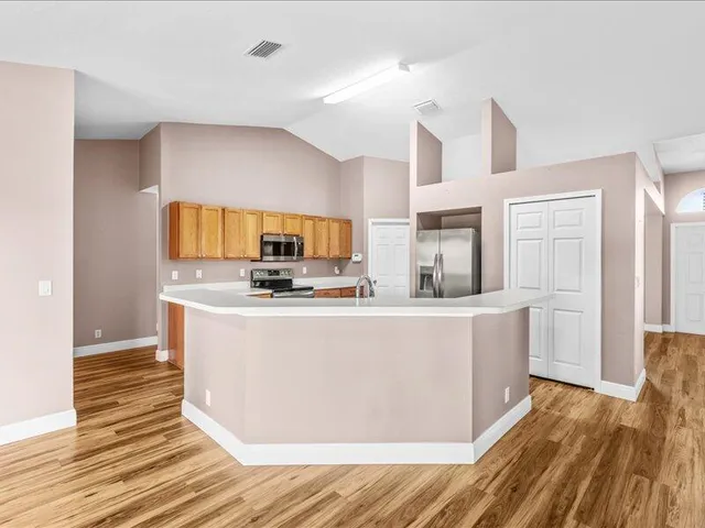 a kitchen with granite countertop wooden cabinets and a stove top oven