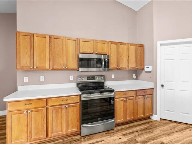 a view of an empty room with chandelier fan