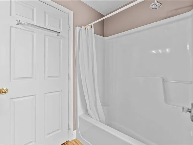 a view of a room with wooden floor and a tub