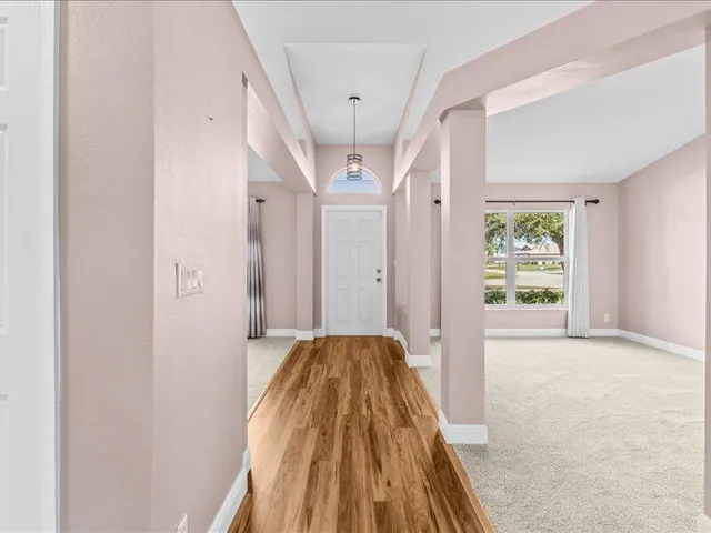 a view of hallway with wooden floor and chandelier